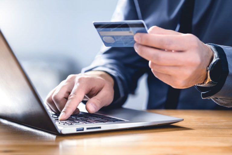 Safe online payment and electronic money transfer security. Pay with digital technology. Man using credit card and laptop to login to internet bank. Financial safety to prevent scam, threat and fraud.