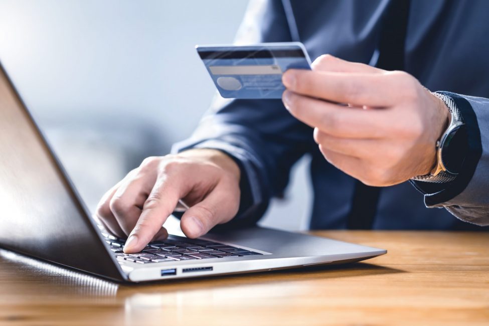 Safe online payment and electronic money transfer security. Pay with digital technology. Man using credit card and laptop to login to internet bank. Financial safety to prevent scam, threat and fraud.